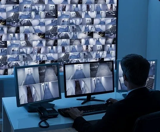 A man sitting at his computer desk in front of multiple monitors.